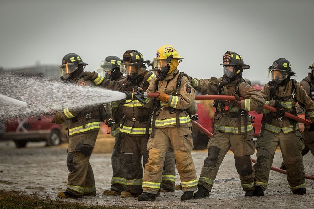 Group of firefighters using hose
